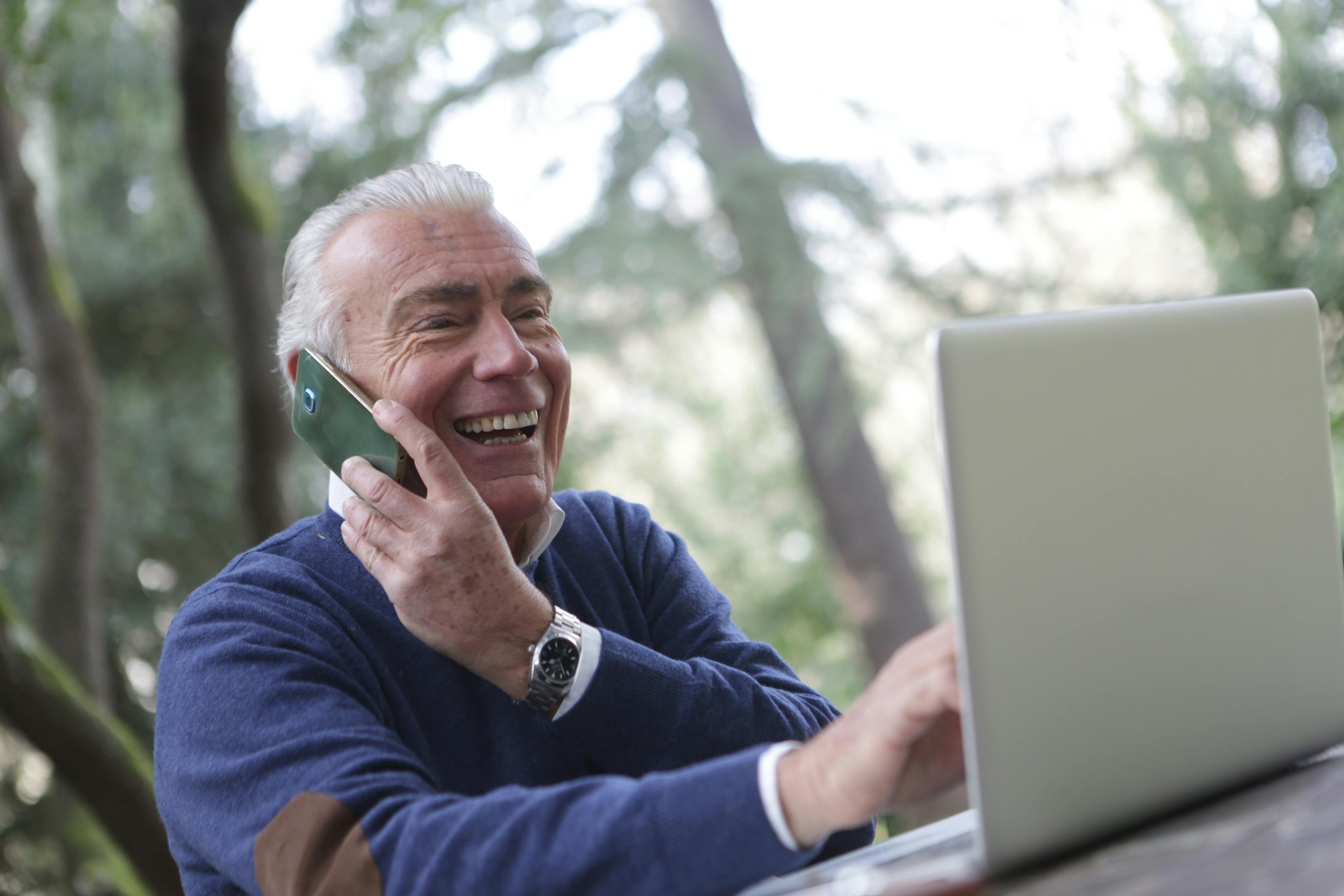 Man embracing digital transformation with phone and laptop